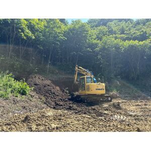 品木ダムの盛土工事で作業する拓友工業の油圧ショベル
