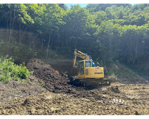 品木ダムの盛土工事で作業する拓友工業の油圧ショベル