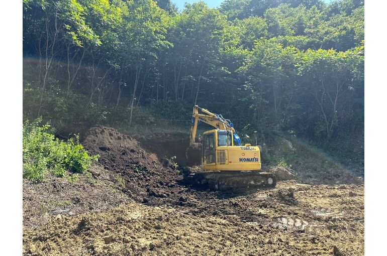 品木ダムの盛土工事で作業する拓友工業の油圧ショベル